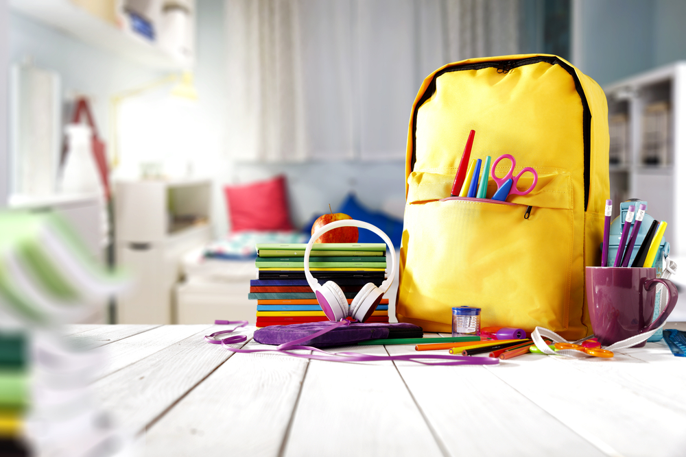Shutterstock_702312109 School supplies on a wooden table in a warm interior