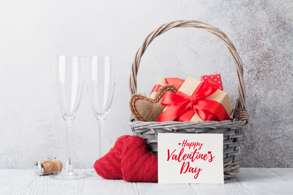 Shutterstock_1283290498 Valentine's day greeting card with knitted hearts and gifts in basket. With space for your greetings